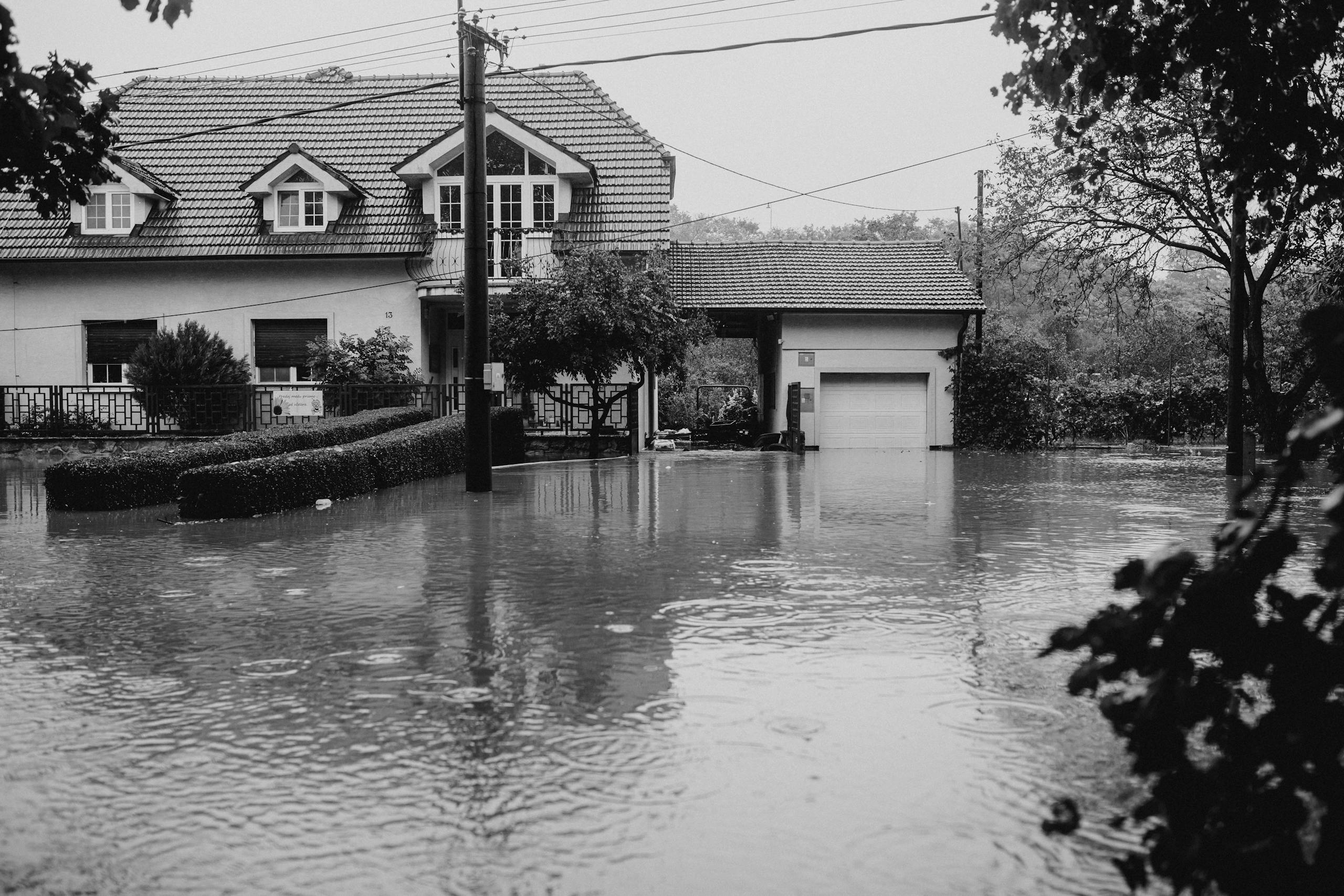 Professional Fire &Amp; Water Damage Restoration In Massachusetts 4 A flooded suburban house surrounded by high water, depicting severe weather impact.