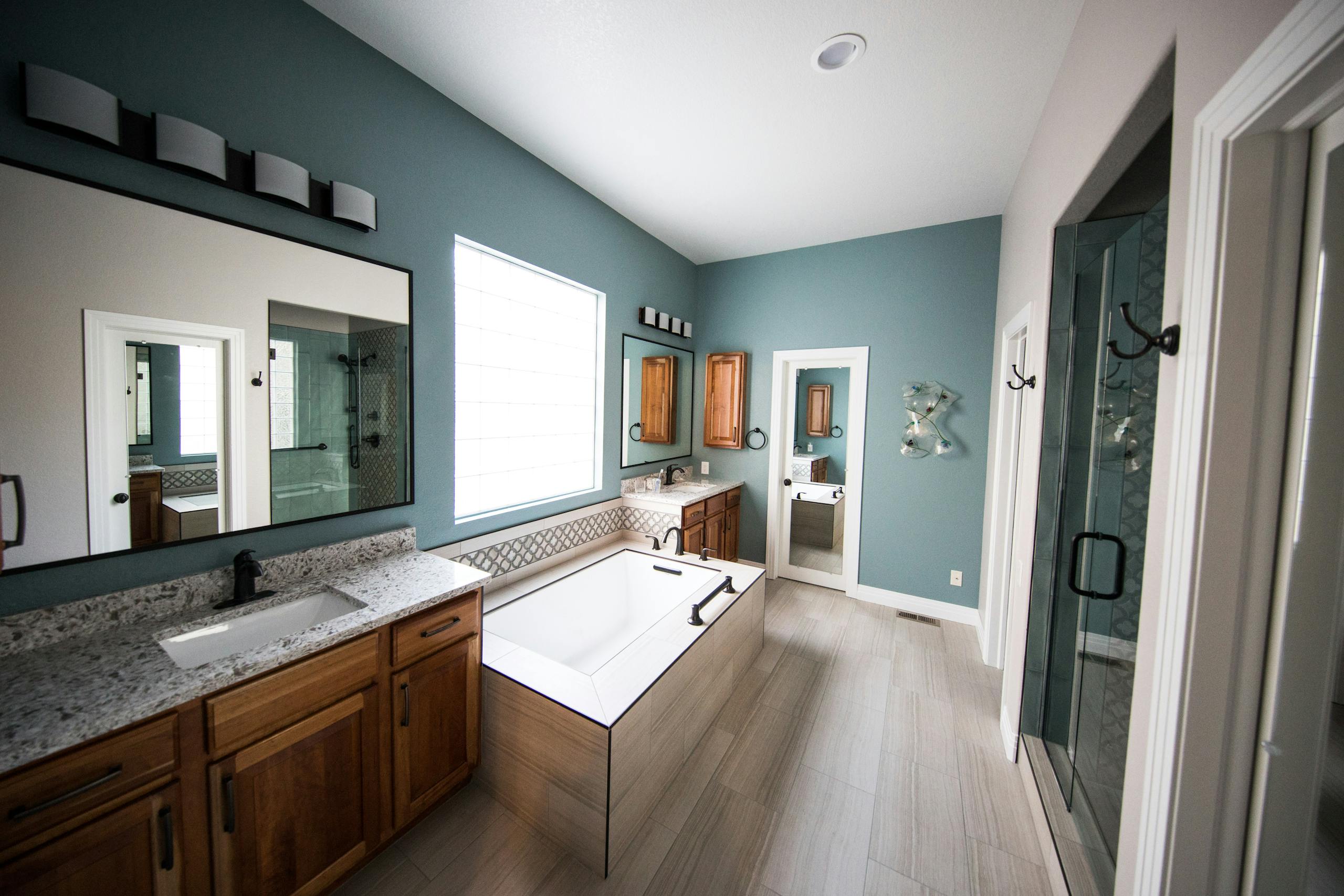 Professional Fire &Amp; Water Damage Restoration In Massachusetts 7 Spacious modern bathroom featuring a freestanding bathtub, wooden cabinets, and granite countertops.